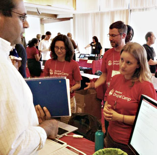 A staff member discusses website options with Stanford Web Services staff.