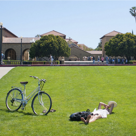 Woman lying in grass alongside bike
