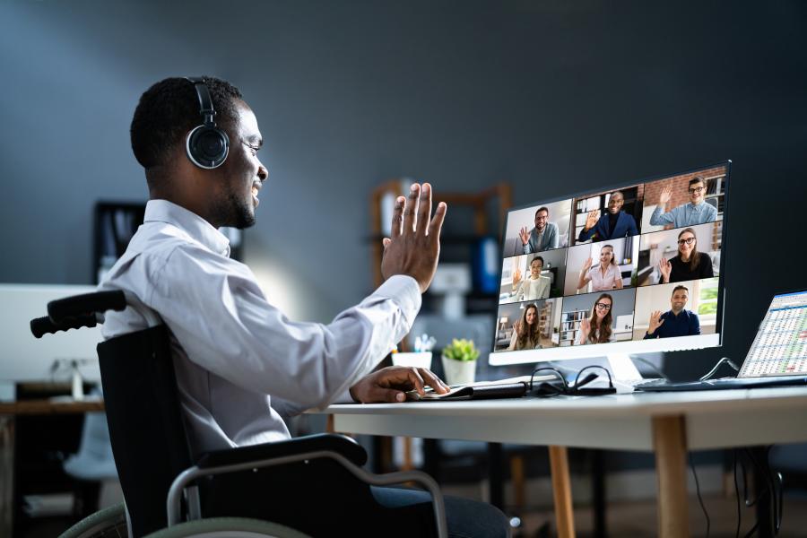 A person waves during a virtual meeting. 