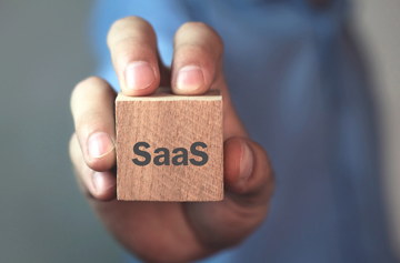 Image of hand holding a cube with the word SaaS on it